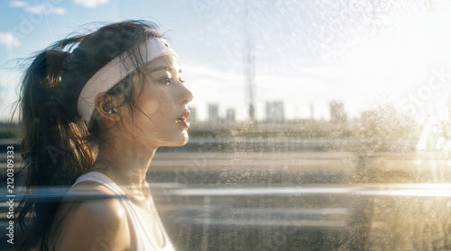 ヘアバンドをつけて汗を拭うスポーティーな女性