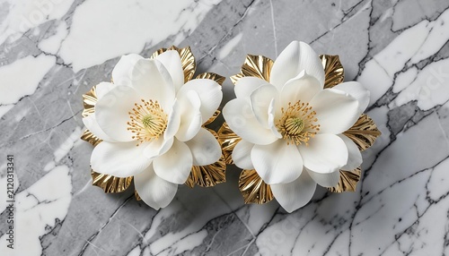 Elegant pair of white flower earrings with gold details placed on a grey marble surface background