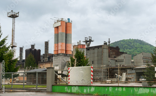 Принти на полотні Industrial complex  with orange and gray storage silos, metal production halls, chimneys, pipelines and security fencing