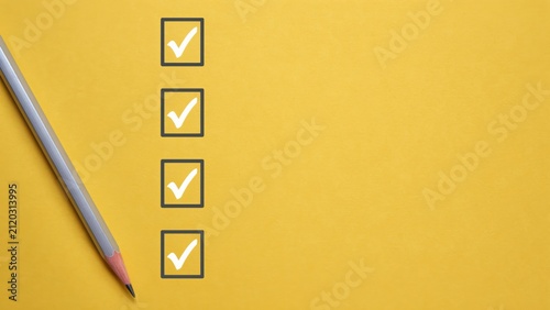 Checklist with four check marks and pencil on yellow background