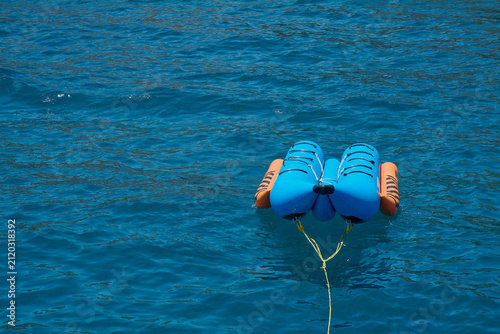 Canvas Print Empty watersport tow toy adrift on calm ocean with copy space