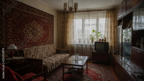 Cozy vintage Soviet living room with patterned carpet, classic furniture and television, showcasing nostalgic Eastern European home interior and retro lifestyle.