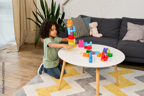 Foto Happy african american boy engaged in imaginative play at home