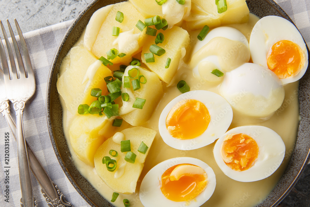 Obraz premium German senfeier boiled eggs in mustard sauce close-up in a plate on the table. Horizontal top view from above