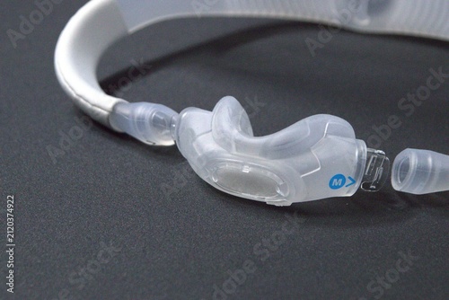 Disassembled CPAP nose mask or nasal CPAP cradle mask shows replaceable parts of CPAP headgear clip. Sleep apnea and sleep disorder with snoring stopped by respirator mask and CPAP machine treatment.