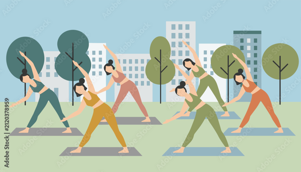 Fototapeta premium Diverse group of active women practicing triangle yoga pose on mats in a green city park with skyscrapers in the background.