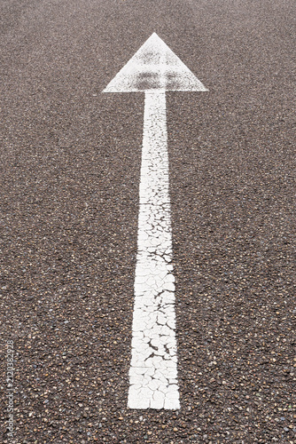 arrow straight ahead on asphalt road