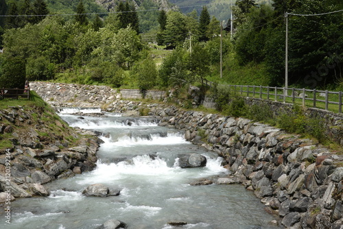 Fast-flowing alpine river with rapids and stone embankments