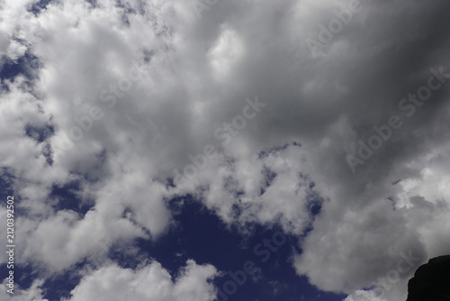 Dramatic cumulus clouds above an alpine mountain peak