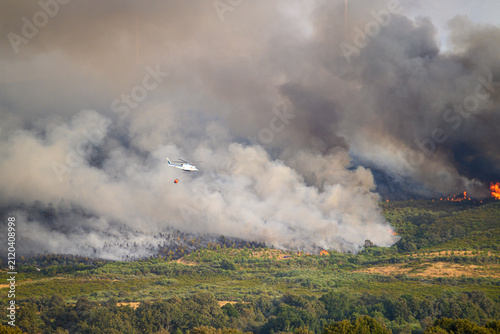 Konstfotografi Firefighting helicopter working over burning hills The Concept of heroic effort
