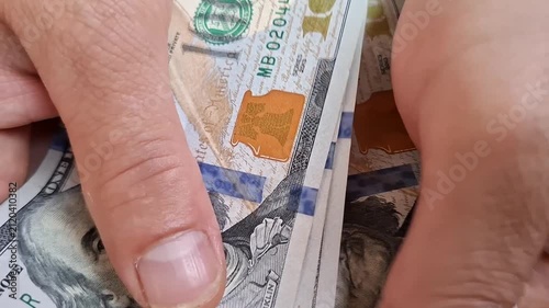 Hand counting United States dollar bills in a close up, personal finance, cash payment, income, and business transaction.