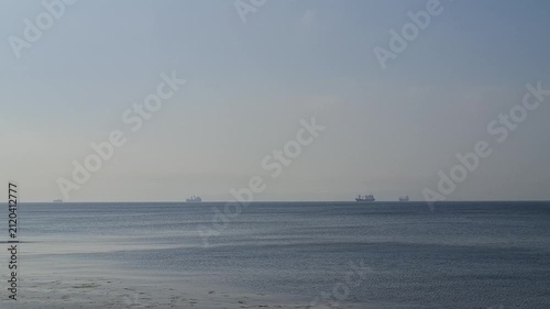 Cargo ships floating on the horizon in the open sea outdoors. cargo ships, open sea horizon, maritime transport backdrop.