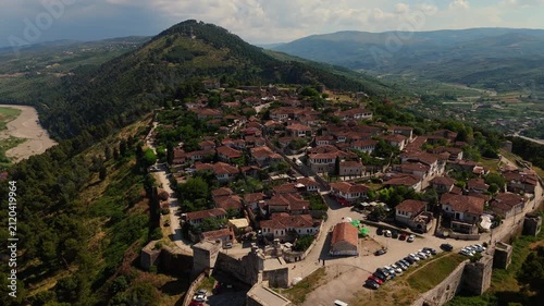 Aerial drone view of the historic Kala neighborhood within Berat Castle walls, showcasing Ottoman houses and the Osum river valley in Albania