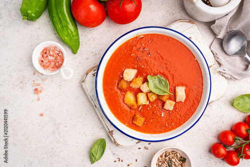 Foto Gazpacho soup in bowl with ingredients over white stone background