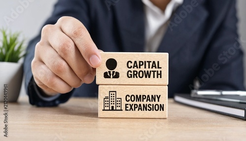 Professional placing wooden block with capital growth and company expansion icons on desk in business meeting setting