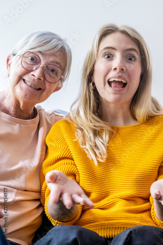 Quadro su tela Grandmother and young woman looking directly at camera with wide eyes and open m