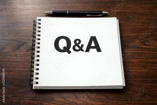 Q&Aが書かれたノートとペンが並ぶ木製デスク
