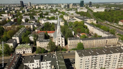 Cinematic drone shot of Warsaw’s Evangelical Reformed Church, capturing its pointed tower, historic details and contrast with modern city buildings.