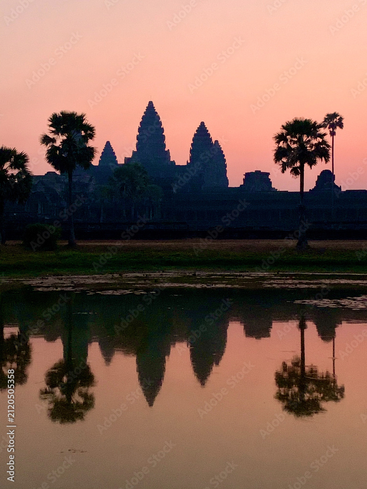 Fototapeta premium Siem Reap, Cambodia - February 20, 2020: Pink Dawn Sky Behind the Silhouette of Angkor Wat