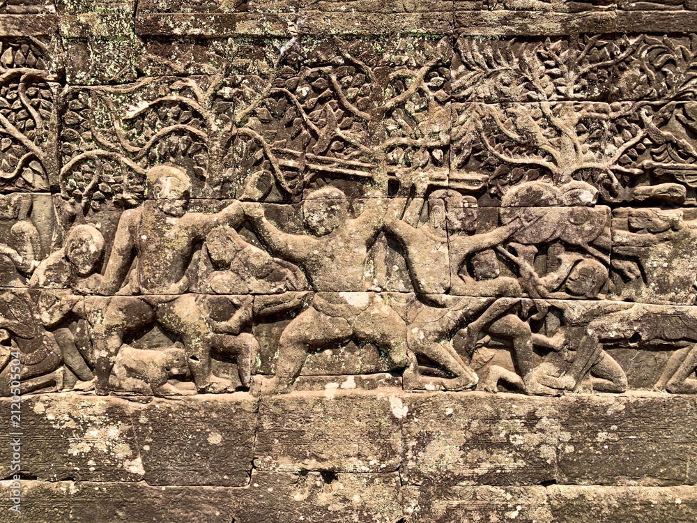 Fototapeta premium Siem Reap, Cambodia - February 20, 2020: Carved Wrestling Scene on the Bayon's Outer Wall