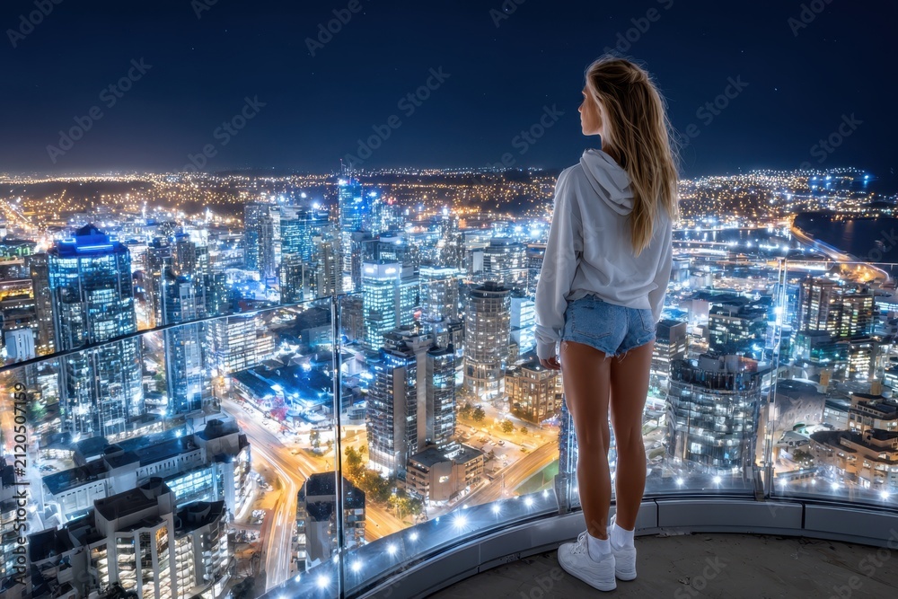 Obraz premium Night Cityscape View From Rooftop Terrace Woman Observing Lights