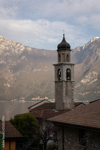 Historic church bell tower overlooking Lake Garda and mountain landscape in Italy