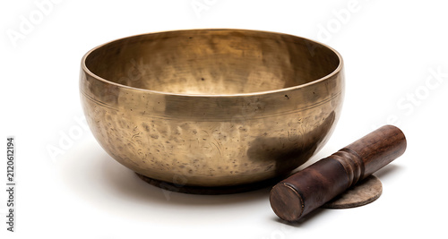 Brass singing bowl with engraved patterns and a wooden mallet on a white background