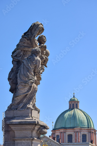The statue of Saint Anne at Charles bridge. Church of St Francis dome in background