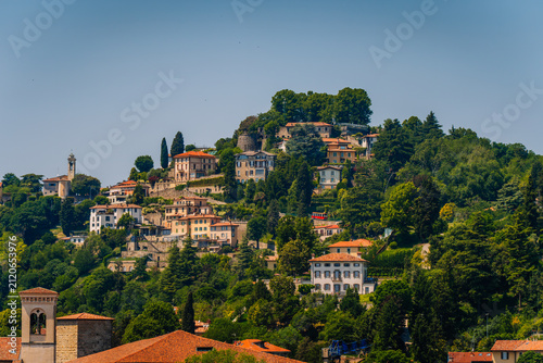 Obraz na plátne Aerial view of Bergamo showcasing hillside residences, lush greenery, and histor
