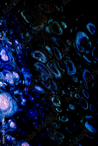 Vibrant background of circular cells in blue-violet hues on black.