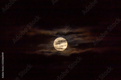 Full moon in the night sky with clouds