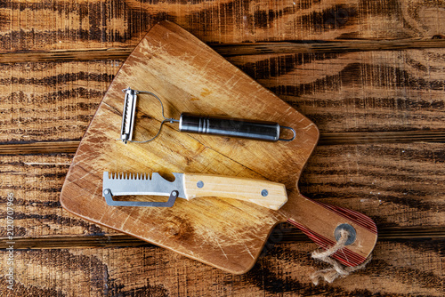 Принти на полотні Two multifunction vegetable peelers compare wooden and dark handles on cutting board
