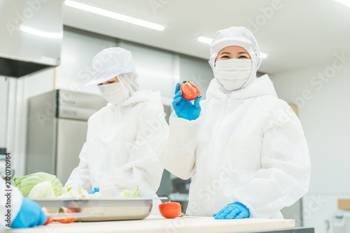 Photography Male and female staff wearing sanitary clothing while working in food processing