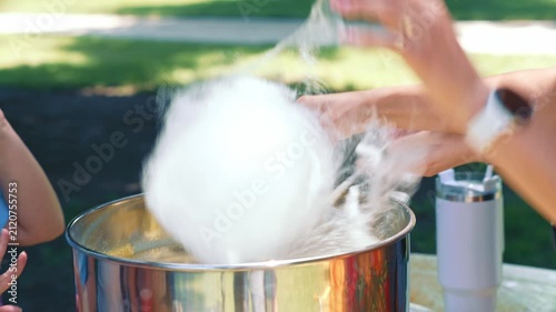 Making Large White Cotton Candy For Child Customer showing the creation of a fluffy sweet dessert at a festive event for family recreation and entertainment