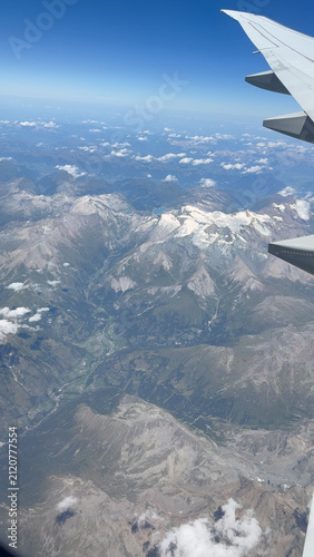 Aerial view of snow capped Alps mountain range from airplane window during flight from Europe.