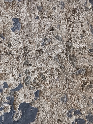Severely weathered concrete texture with heavily peeled paint and rough eroded surface.