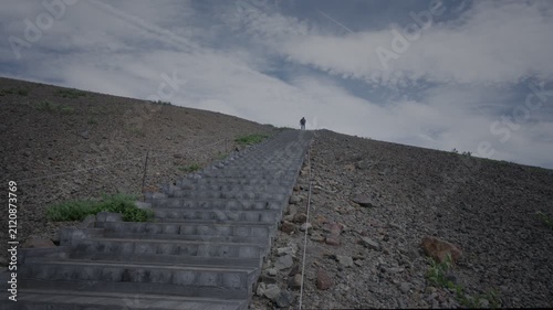 火山礫に囲まれた階段を登っていく人