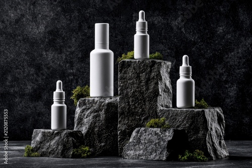 Skincare dropper bottles standing on mossy granite blocks in dark moody studio for organic luxury cosmetic branding