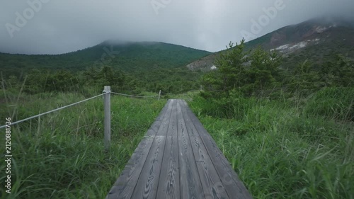雨が降り出しそうな空の下で木道を歩く