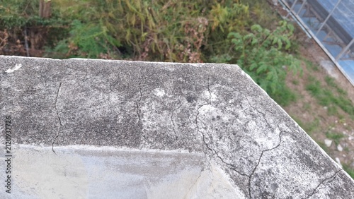Weathered concrete wall edge with cracks and mold