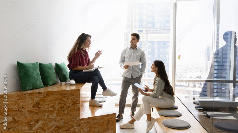 Obraz premium Group of diverse professional team members collaborating on corporate tasks, discussing project during meeting in coworking city office. Business communication, strategy planning, teamwork concept