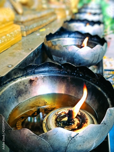 Obraz na płótnie Glowing Oil Lamps at a Buddhist Temple – Symbol of Faith and Serenity