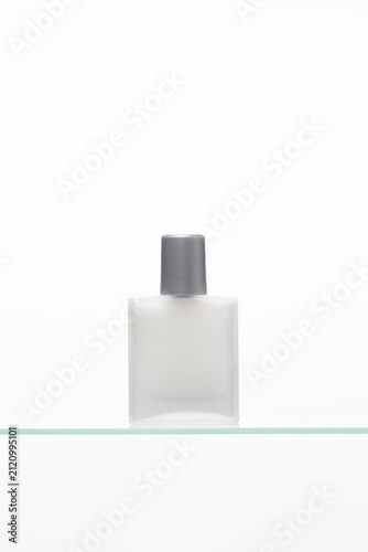 Canvas Print Premium Men's Cosmetic Product frosted aftershave bottle on glass shelf, perfect for minimalist lifestyle themes and bathroom vanity concepts