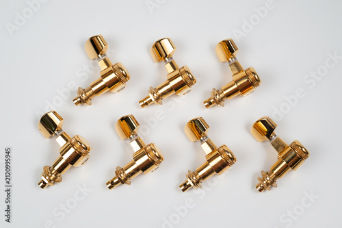 Set of seven gold-colored metal guitar tuning pegs.