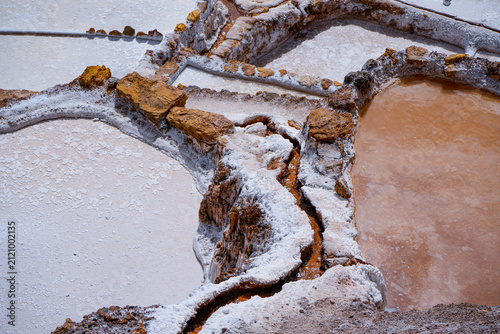 Cuadro en lienzo Aerial view of crystallized salt ponds beside an orange mineral water channel