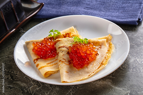Принти на полотні Gourmet crepes with red caviar and herbs served on white plate