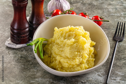 Quadro su tela Homemade mashed potatoes in white bowl with fresh vegetables on rustic backgroun