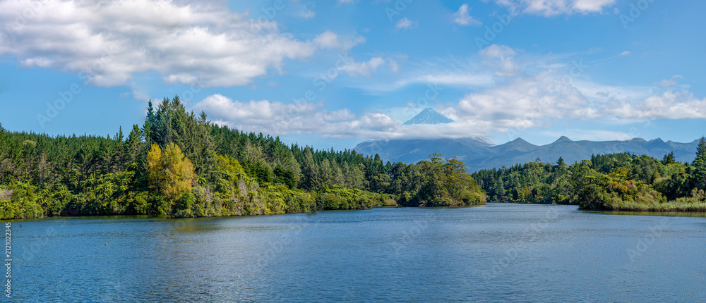 Obraz premium Lake Mangamahoe, Mount Taranaki, New Plymouth, Neuseeland, Pinus radiata, Vulkan Egmont, Stausee mit Wald und Wolken am Sommertag