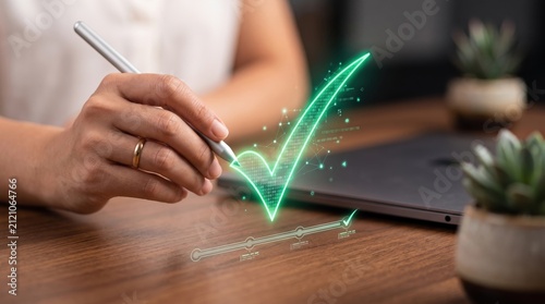 Businesswoman drawing green holographic check mark, digital verification concept, approval success technology innovation symbol on wooden desk background with laptop and plants.