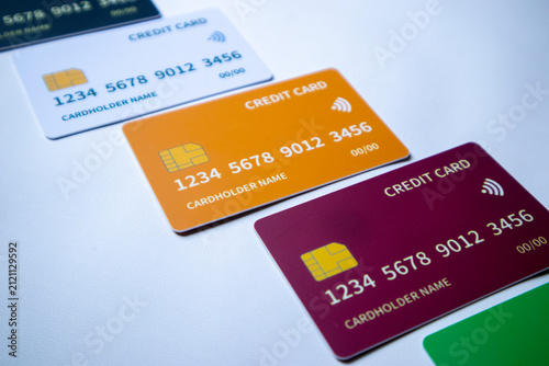 Macro angled diagonal row of multi-colored credit and debit cards on a white surface